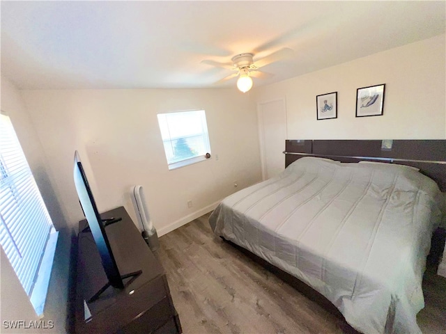 bedroom featuring hardwood / wood-style floors, ceiling fan, and lofted ceiling