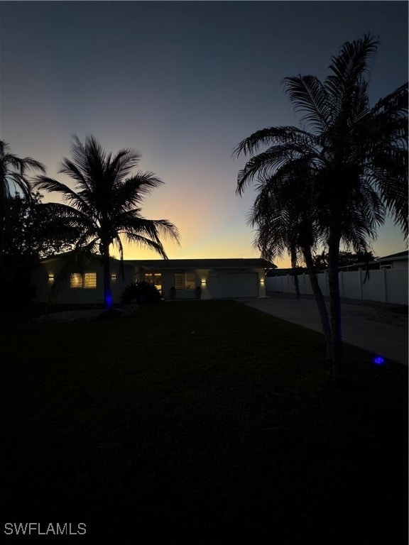 yard at dusk featuring a garage