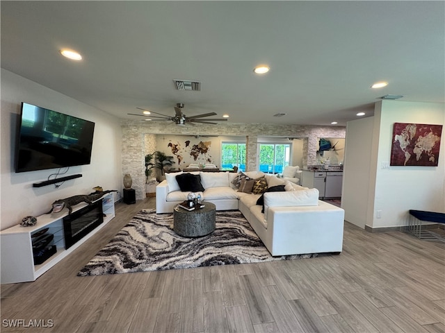 living room with ceiling fan and light hardwood / wood-style flooring