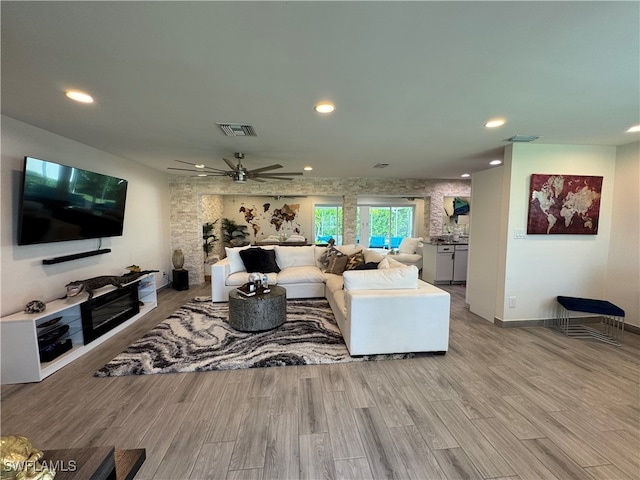 living room featuring ceiling fan and light hardwood / wood-style floors