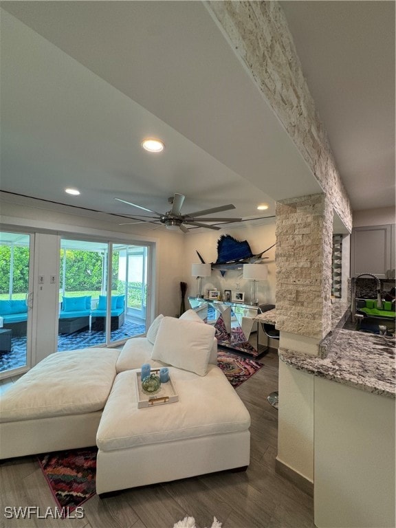 living room featuring dark hardwood / wood-style floors, ornate columns, ceiling fan, and sink