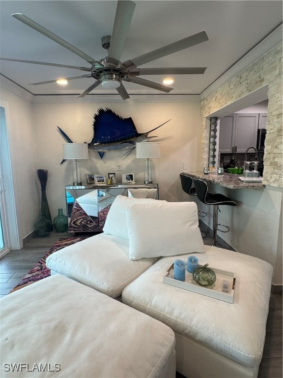 living room featuring dark hardwood / wood-style floors, ceiling fan, and crown molding