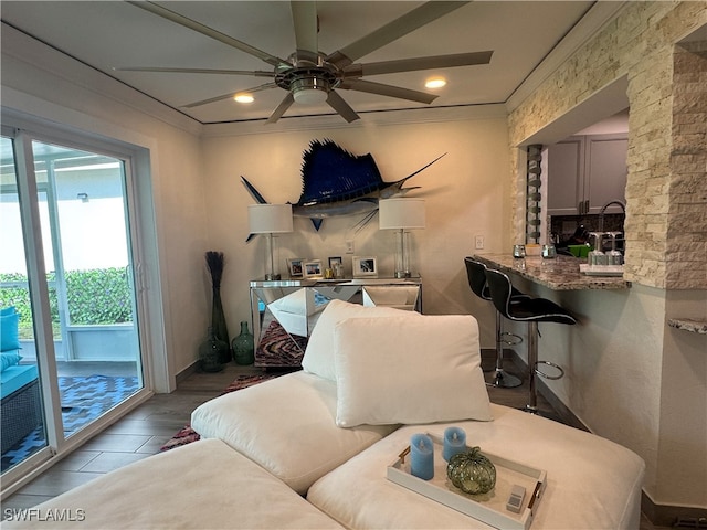 living room featuring light hardwood / wood-style floors, ceiling fan, and ornamental molding