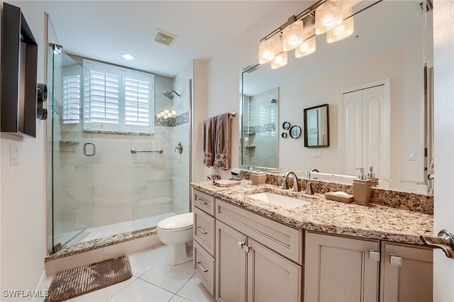 bathroom featuring tile patterned floors, vanity, toilet, and a shower with shower door