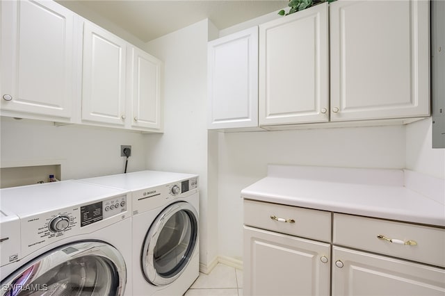 clothes washing area featuring separate washer and dryer, light tile patterned flooring, and cabinets