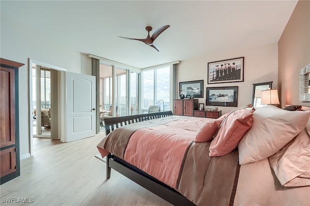 bedroom featuring light wood-type flooring, expansive windows, multiple windows, and ceiling fan