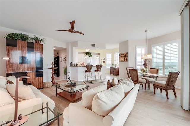 living room featuring light wood-type flooring, a wealth of natural light, and ceiling fan