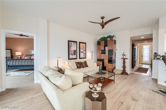 living room with light hardwood / wood-style flooring and ceiling fan