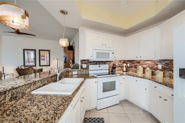 kitchen featuring backsplash, white appliances, sink, white cabinetry, and hanging light fixtures