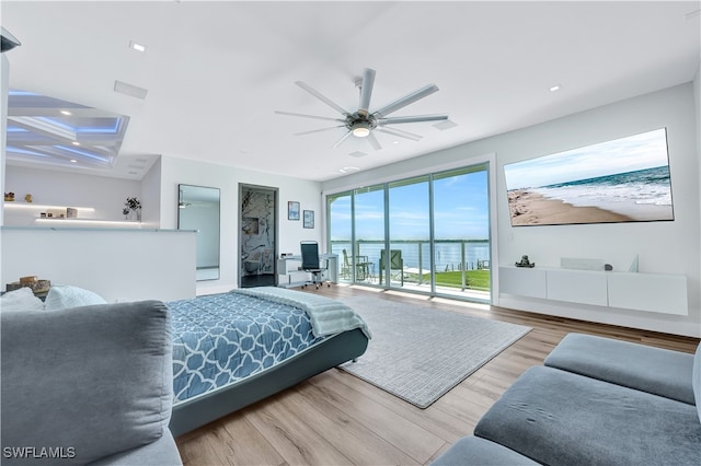 bedroom with access to outside, a water view, light hardwood / wood-style flooring, and ceiling fan