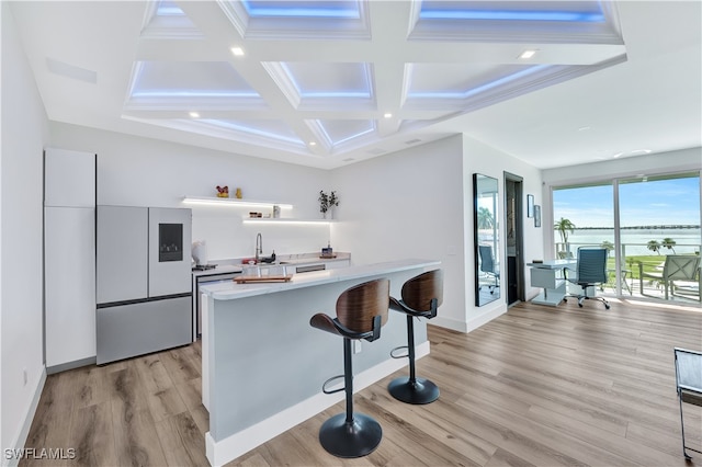 kitchen featuring a kitchen breakfast bar, coffered ceiling, beamed ceiling, white cabinets, and light hardwood / wood-style floors