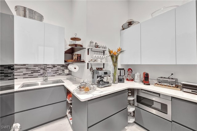 kitchen with white cabinetry, gray cabinetry, and sink