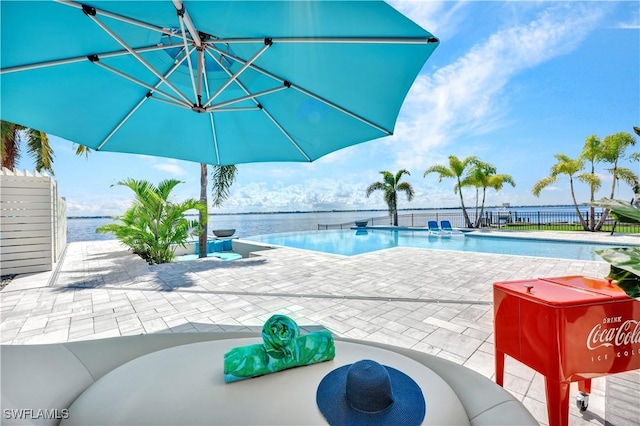 view of swimming pool featuring a water view and a patio