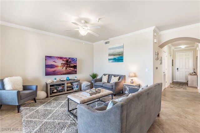 tiled living room with ceiling fan and crown molding