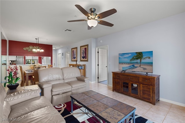 living room with light tile patterned floors and ceiling fan with notable chandelier