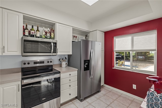 kitchen featuring white cabinets, appliances with stainless steel finishes, and light tile patterned floors