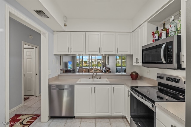 kitchen featuring light tile patterned flooring, sink, white cabinetry, and stainless steel appliances