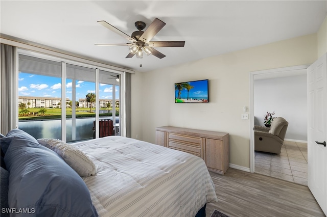 bedroom featuring access to exterior, ceiling fan, and light hardwood / wood-style flooring