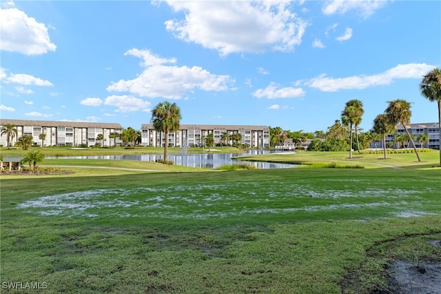 view of property's community with a lawn and a water view