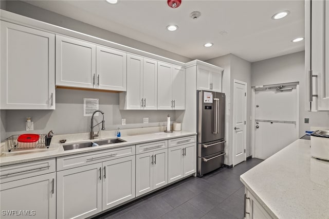 kitchen featuring dark tile patterned flooring, white cabinetry, sink, and high quality fridge