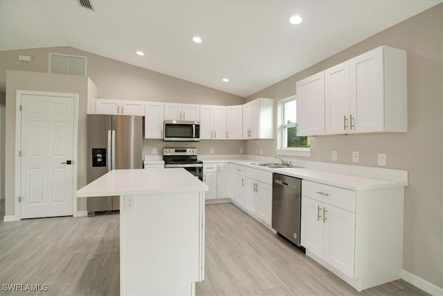 2902 40th St W, Lehigh Acres, FL 33971 - kitchen featuring appliances with stainless steel finishes, a sink, lofted ceiling, a center island, and white cabinetry