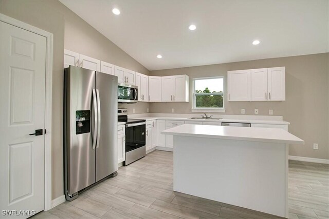 2902 40th St W, Lehigh Acres, FL 33971 - kitchen featuring appliances with stainless steel finishes, a sink, light countertops, vaulted ceiling, and a center island