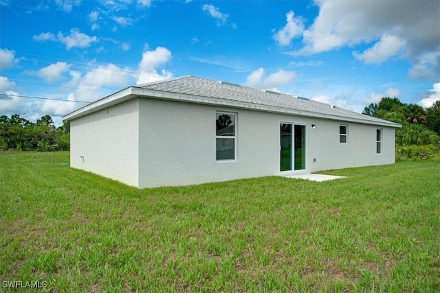 2902 40th St W, Lehigh Acres, FL 33971 - rear view of property with a lawn, stucco siding, and a shingled roof