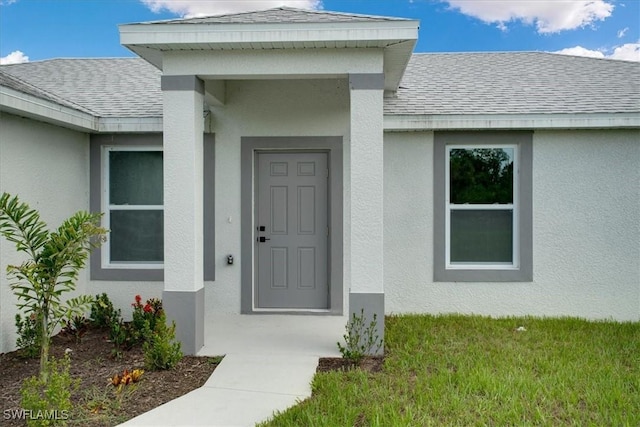 2902 40th St W, Lehigh Acres, FL 33971 - doorway to property featuring roof with shingles and stucco siding