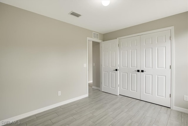 unfurnished bedroom with light wood-type flooring and a closet