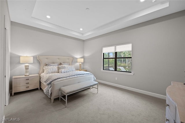 carpeted bedroom featuring a tray ceiling