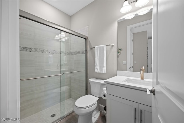 bathroom featuring wood-type flooring, vanity, toilet, and an enclosed shower