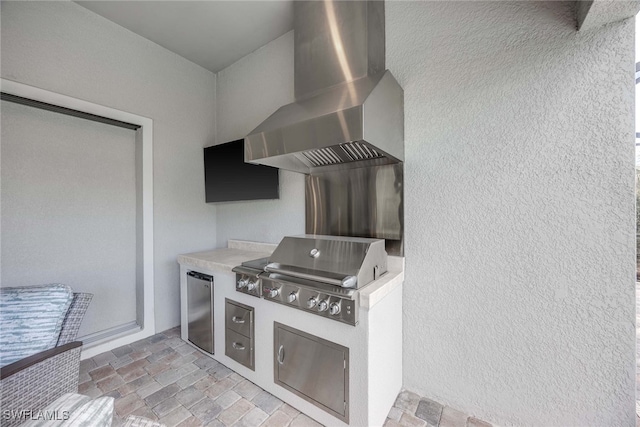 kitchen with wall chimney exhaust hood and stainless steel refrigerator