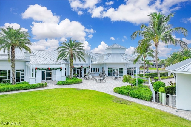 rear view of property featuring a patio area and a lawn