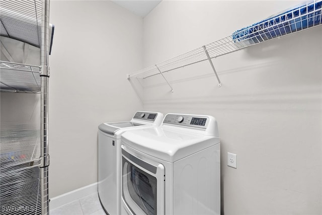 laundry area featuring washer and clothes dryer and light tile patterned flooring