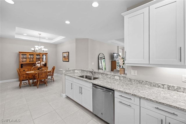 kitchen with a raised ceiling, white cabinetry, stainless steel dishwasher, and sink