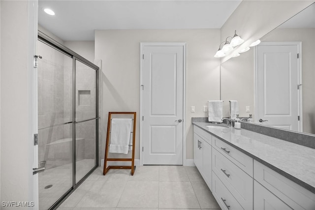 bathroom with tile patterned flooring, vanity, and a shower with shower door