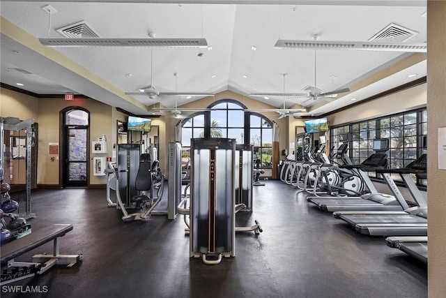 workout area featuring ceiling fan, a healthy amount of sunlight, and vaulted ceiling