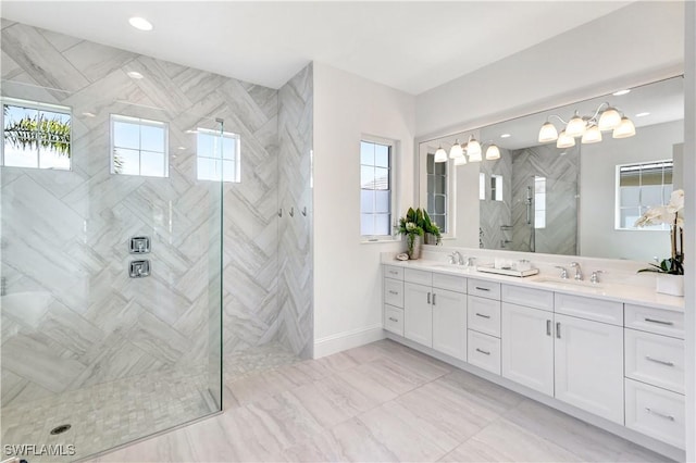 bathroom with a tile shower and vanity