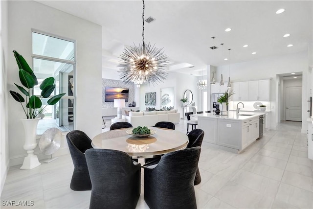 tiled dining room featuring an inviting chandelier, plenty of natural light, and sink