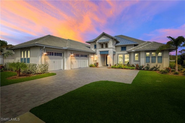 view of front facade featuring a garage and a yard