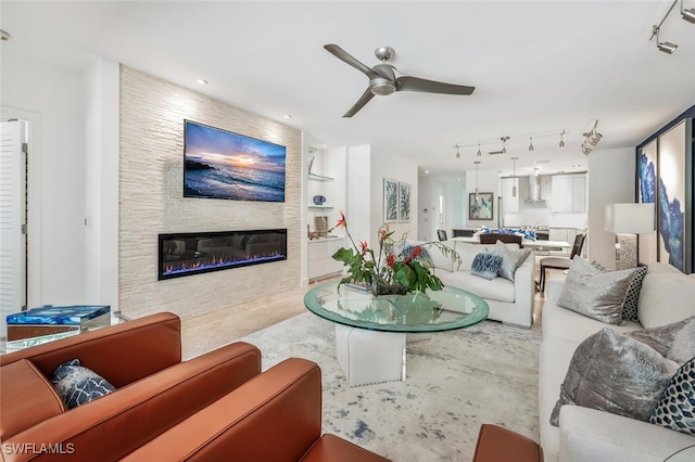 living room with a fireplace and ceiling fan