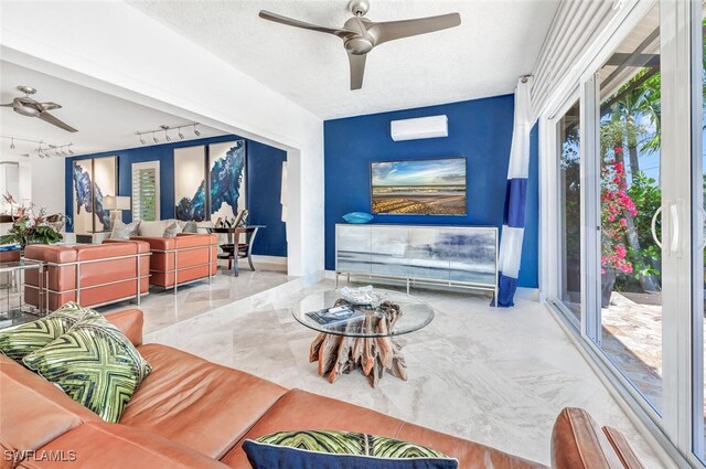 living room with a wall mounted air conditioner, ceiling fan, a textured ceiling, and rail lighting