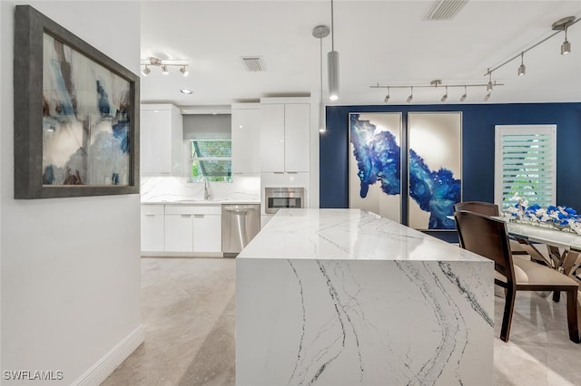 kitchen featuring backsplash, stainless steel dishwasher, sink, pendant lighting, and white cabinetry