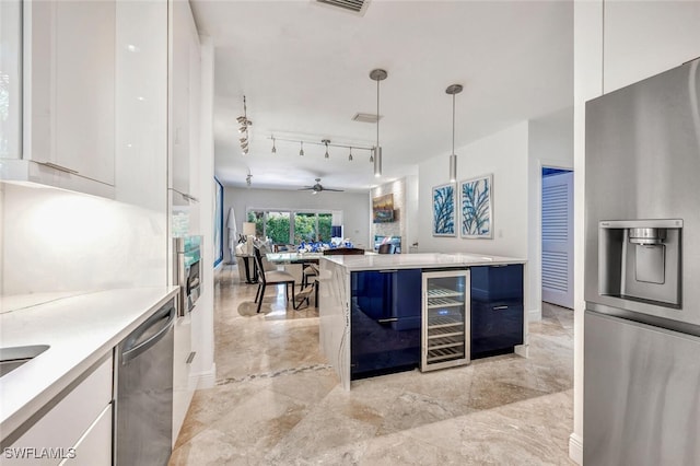 kitchen with appliances with stainless steel finishes, white cabinetry, and pendant lighting