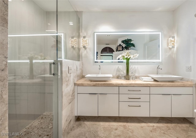 bathroom featuring vanity and a shower with shower door