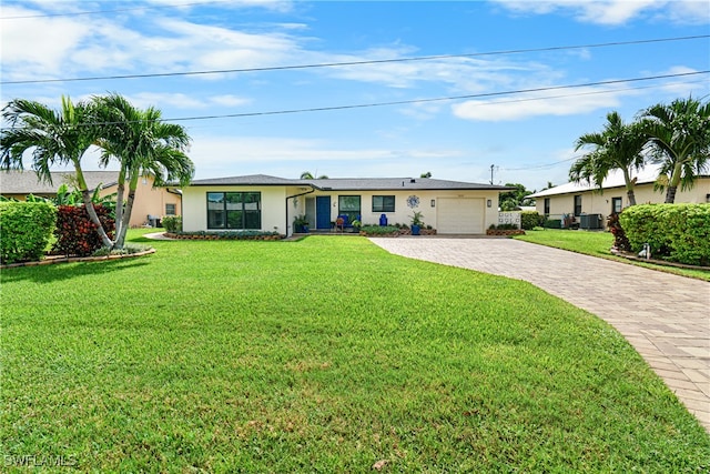 ranch-style home featuring central AC unit, a front yard, and a garage