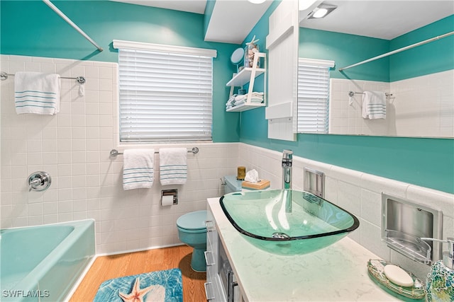 bathroom featuring toilet, vanity, tile walls, and hardwood / wood-style flooring