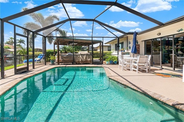 view of pool featuring glass enclosure and a patio