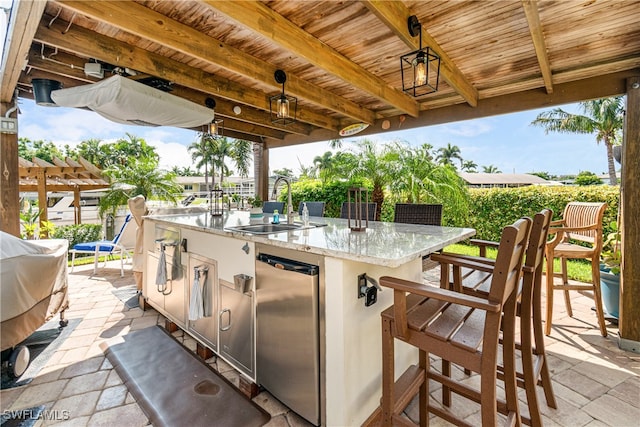 view of patio with area for grilling and an outdoor wet bar