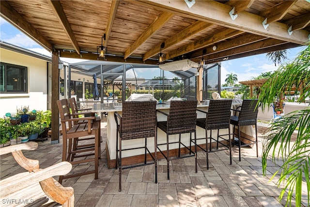 view of patio / terrace featuring exterior bar and a lanai